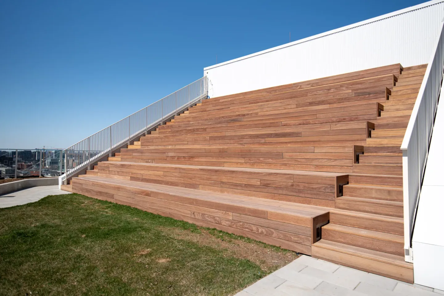 Finished Cumaru bleacher seating on a condo terrace, showing warm brown boards and natural grain variation across the stepped structure