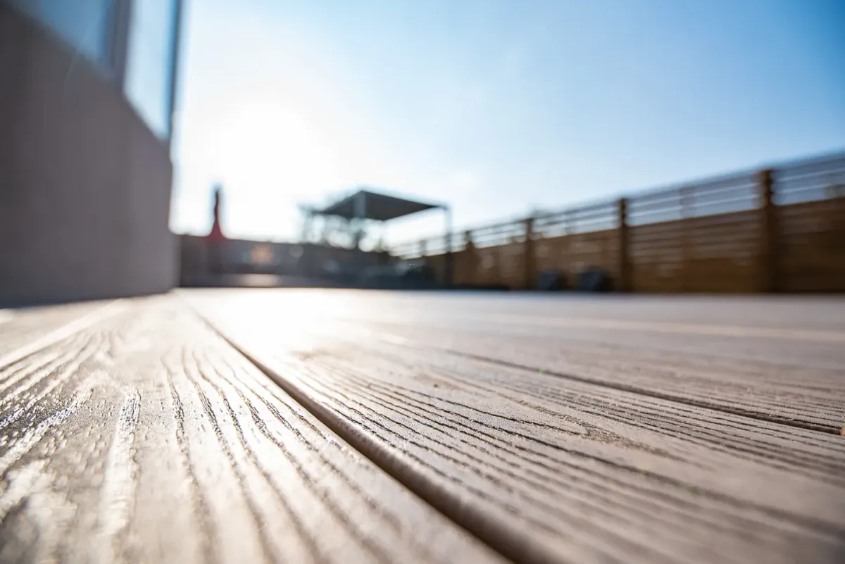 Close-up of grey Fiberon composite board grain and the gap between boards in sunlight