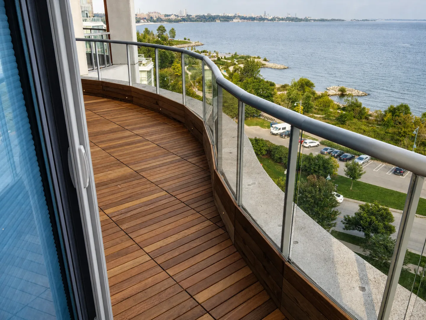 Curved terrace finished with Ipe tile decking and a glass railing.