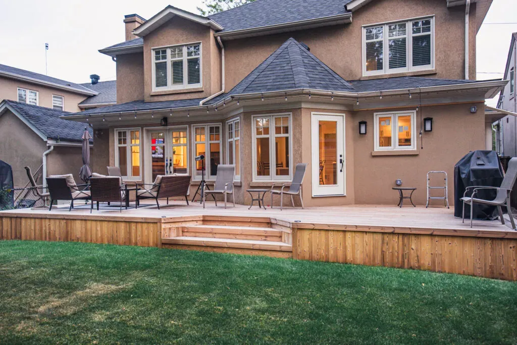 Completed wood deck with broad stairs opening onto a lawn
