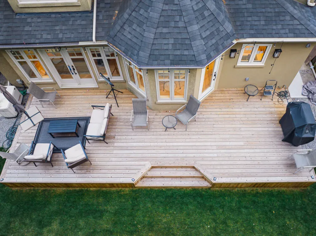 Overhead view of a wood deck with angled steps, seating and a garden edge