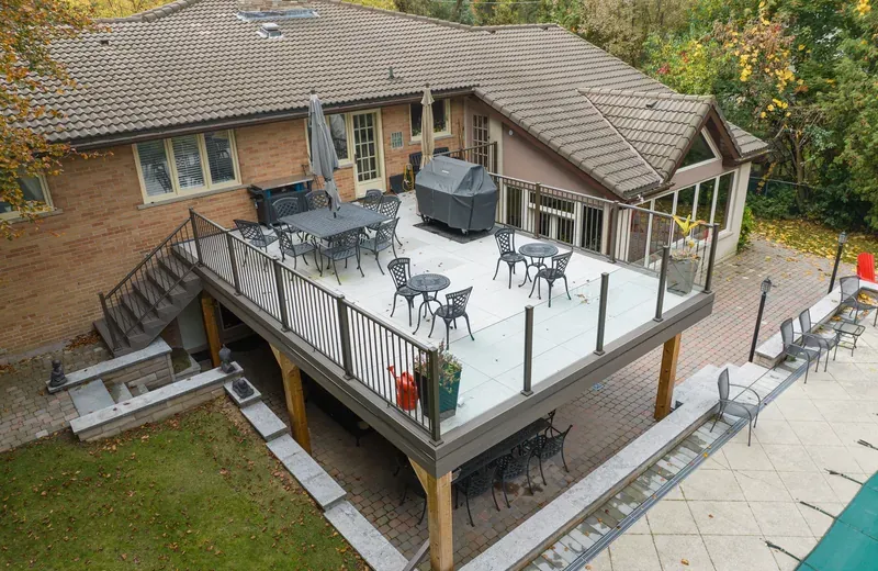 Raised backyard deck with an aluminum picket guard, a glass panel section, and a stair flight with its own guard.